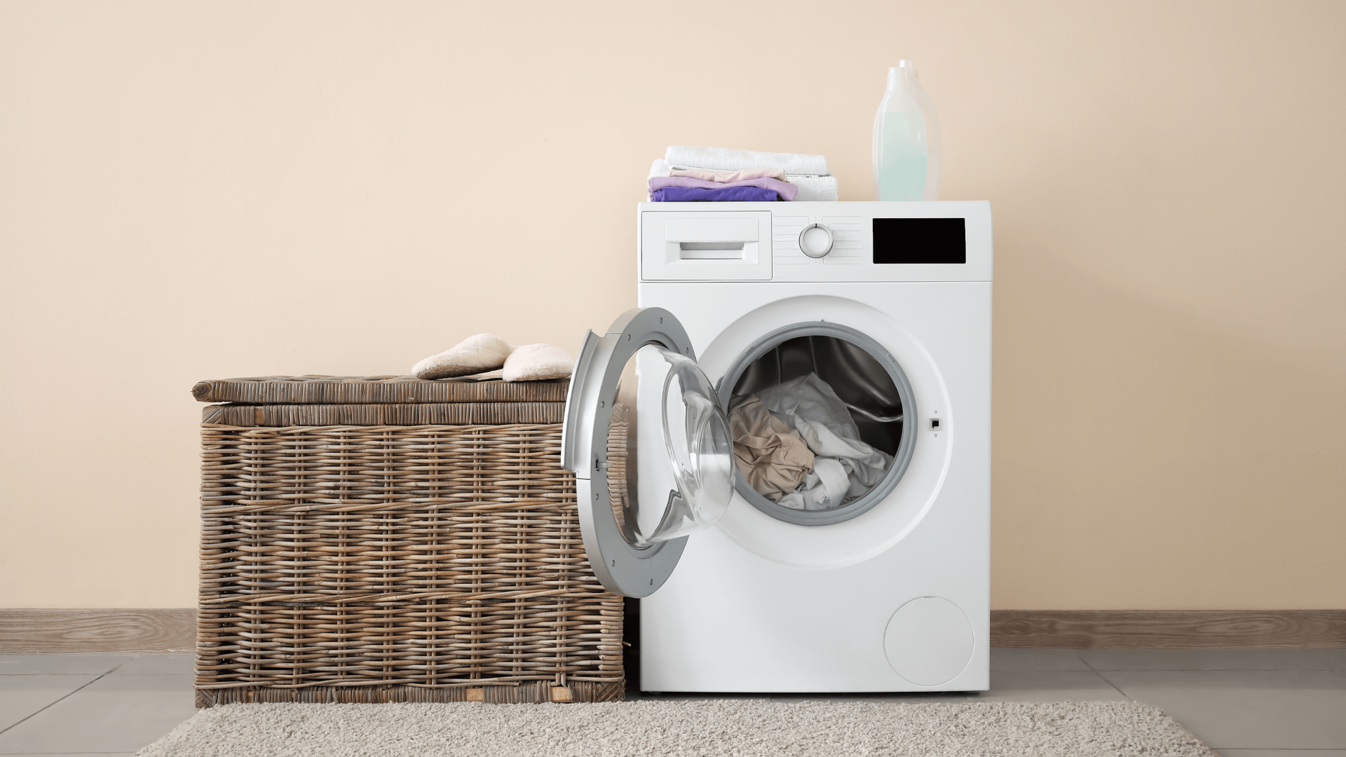 Como fazer a limpeza da máquina de lavar? - Máquina de lavar ao lado de cesto de roupas